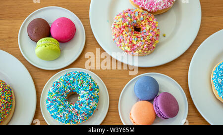 Französische macarons und Donuts auf Holztisch, Ansicht schließen mit Details, Ansicht von oben Stockfoto