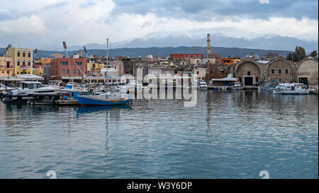 Altstadt von Chania mit Blick auf den Hafen im Winter mit Schnee auf den Bergen im Hintergrund. Stockfoto