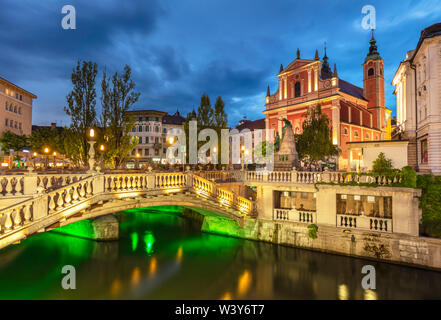 Die Rosa Franziskanerkirche und die drei Brücken über den Fluss Ljubljanica nachts Ljubljana Slowenien EU-Europ Stockfoto