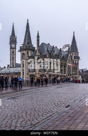 Touristen machen Fotos stehen auf Sint-Michielsbrug oder St Michael's Bridge in der Nähe von alten Postgebäude in nebligen Winter morgen. Stockfoto