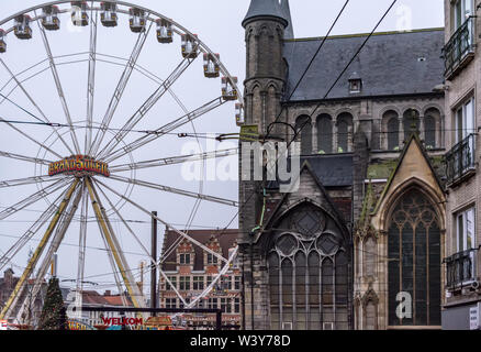 Riesenrad und Weihnachtsmarkt in der Innenstadt in der Nähe des gotischen St. Nicholas' Church (sint-niklaaskerk) im nebligen Winter morgen. Stockfoto