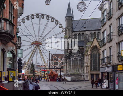 Riesenrad und Weihnachtsmarkt in der Innenstadt in der Nähe des gotischen St. Nicholas' Church (sint-niklaaskerk) im nebligen Winter morgen. Stockfoto