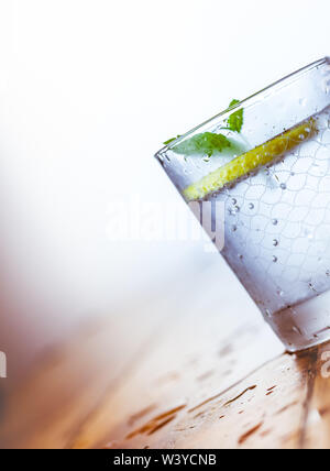Ein Becherglas und einen Krug kalten Limonade auf einem weißen Hintergrund Holz umgeben von Zitronen Stockfoto