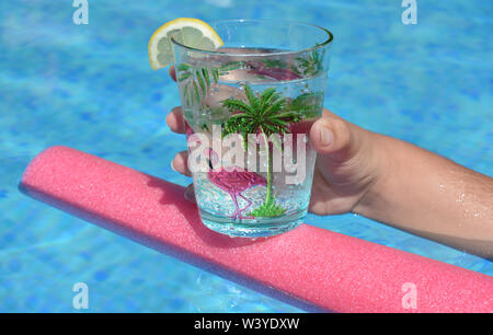 Junge Frau mit einem kühlen Getränk schwimmt auf einem Pool Nudel in einem Schwimmbad. Sommer vibes, cool Bleiben, Spaß haben. Stockfoto