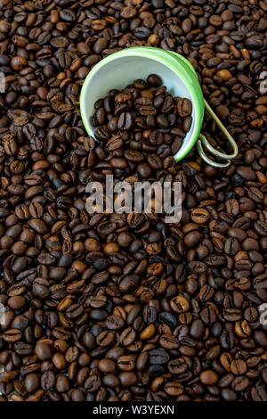 Grüne Schale unter eine Menge Kaffee Bohnen. Stockfoto
