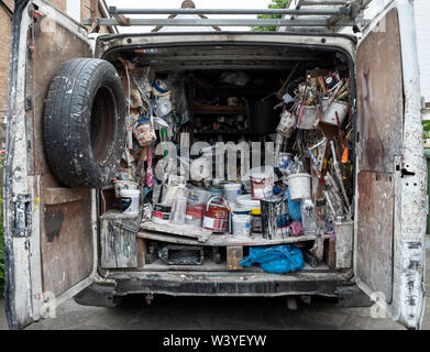 Innenraum der Hauptdekorateur van fotografiert von hinten, voll von alten Dosen Farbe, Zubehör, Bürsten und andere Verbrauchsmaterialien Stockfoto