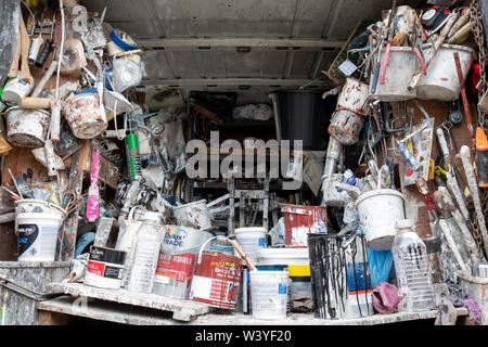 Innenraum der Hauptdekorateur van fotografiert von hinten, voll von alten Dosen Farbe, Zubehör, Bürsten und andere Verbrauchsmaterialien Stockfoto