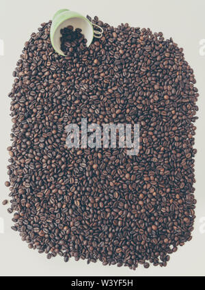 Grüne Schale unter eine Menge Kaffee Bohnen. Stockfoto