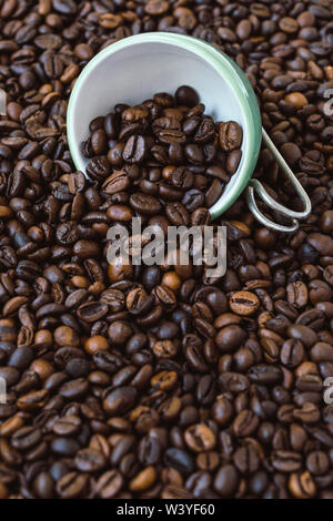Grüne Schale unter eine Menge Kaffee Bohnen. Stockfoto