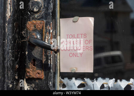 Seaton, Devon, England, UK. Juli 2019. Hinweis auf einem alten Cafe nebenan. Toiletten nur für Kunden verwenden. Stockfoto