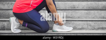 Frau binden Schuhbändern auf Laufschuhe vor Praxis. Runner immer bereit für Ausbildung. Sport Active Lifestyle Konzept. Outdoor Training Konzept für Stockfoto