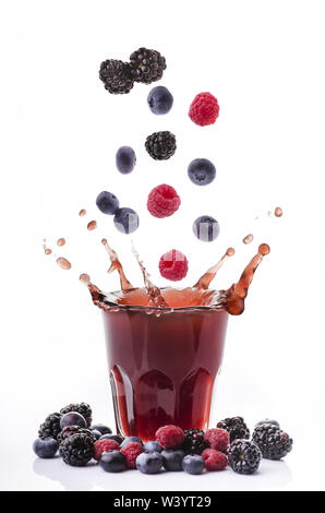 Beeren fallen in ein Glas mit Saft Generieren eines Splash Stockfoto