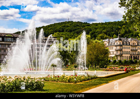 Fächerartige Fontäne im Rosengarten von Bad Kissingen, Deutschland. Der Rosengarten mit Wasserspiel im Zentrum von Bad Kissinger. Die Gärten und Parks sind charakteristisch für das Stadtbild einer Kurstadt. Bad Kissing bietet 110 km Promenaden und Wanderwege. Direkt am Rosengarten fand 1874 die Attentat auf Otto von Bismarck statt, durch die er in ganz Europa berühmt wurde. Stockfoto