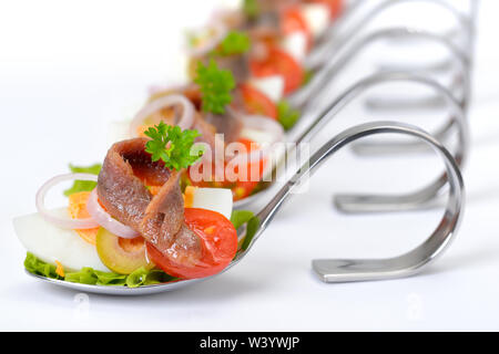 Feine Fisch Vorspeisen mit Anchovisfilets und Eier auf dem Löffel auf weißem Hintergrund Stockfoto