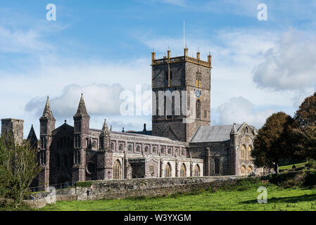 St Davids Cathedral, Pembrokeshire, Wales. Blauer Himmel mit grünem Feld im Vordergrund. Stockfoto