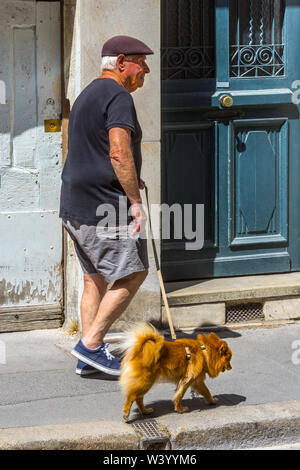 Ältere Mann seinen Hund Pflaster - Frankreich. Stockfoto