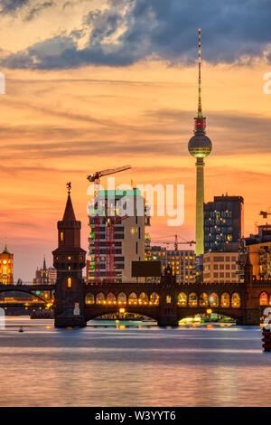 Dramatischer Sonnenuntergang an der Oberbaumbrücke und dem berühmten Fernsehturm in Berlin Stockfoto