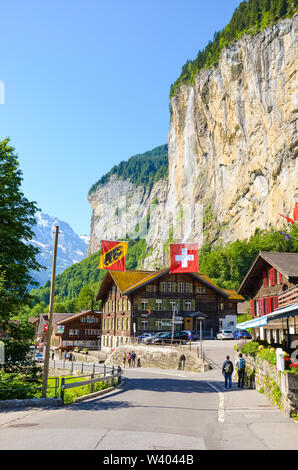 Lauterbrunnen, Schweiz - 16. Juli 2019: Schöne Staubbachfall im malerischen Dorf Lauterbrunnen im Sommer Saison mit lokalen Chalets und touristische fotografiert. Beliebtes Touristenziel. Stockfoto