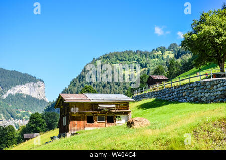 Schöne Hütte in der Nähe von Lauterbrunnen in den Schweizer Alpen. Atemberaubenden alpinen Landschaft in der Sommersaison. Sonnigen Tag, grüne Hügel. Chalet in der Schweiz. Schweizer Alpen. Stockfoto