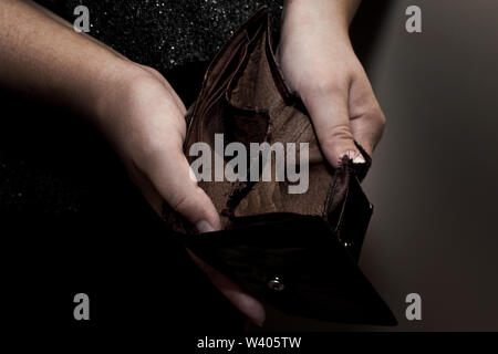 Alte, leere Brieftasche in den Händen von Frauen. Armut Konzept. Geldbeutel für ändern Stockfoto