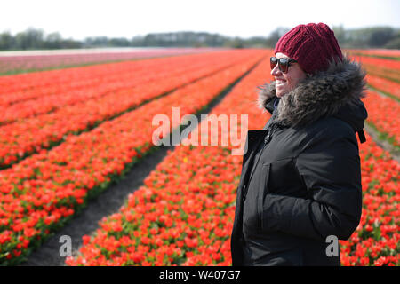 Junge Frau, im tulpenfeld lächelnd im Frühling. Stockfoto