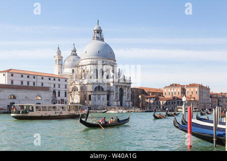 Gondeln und Vaporetto Wasserbus (Wasser Bus Öffentliche Verkehrsmittel) am Grand Canal vor der Basilika di Santa Maria della Salute, Venedig, Venetien, Ital Stockfoto