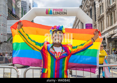 Asiatische Männer in einem Regenbogen Anzug hält einen Regenbogen Flagge im Pride in London Stockfoto