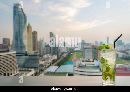 Mojito cocktail am Tisch in der Bar auf der Dachterrasse mit Blick auf die Stadt Bangkok in Bangkok Thailand Punkt. Schöne Dachterrasse mit Bar in Bangkok. Stockfoto