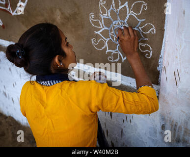 PUSHKAR, INDIEN - ca. November 2018: Indische Frau Malerei indischen Designs bei einem Wettbewerb in der Pushkar Camel Fair. Es ist eines der weltweit größten Stockfoto