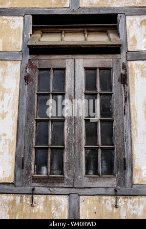 Fenster mit der aus Holz geschnitzte Architrav im alten Holzhaus. Stockfoto