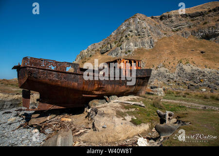 Rusty abgebrochenen historischen Schiffswrack an der Küste Stockfoto