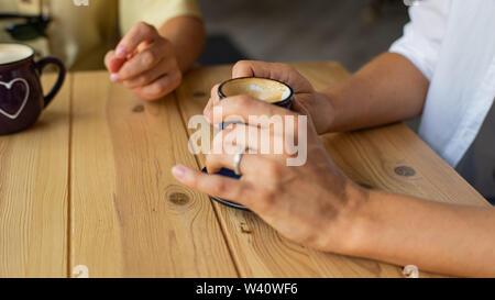 Schöne weibliche Hände hält eine Tasse Kaffee in einem Cafe. Stockfoto