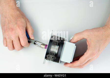 Alte ältere kranke home Handwerker Reparaturen der Mikrowelle magnetron von elektrischen Backofen. Home closeup Schuß Stockfoto