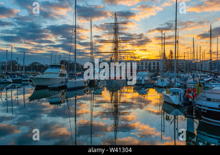 Jachthafen Oostende (Ostende) bei Sonnenuntergang mit Rathaus, Westflandern, Belgien. Stockfoto