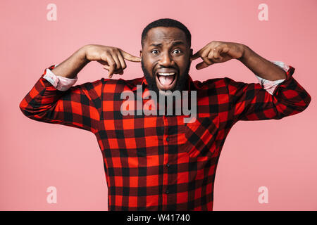 Porträt von einem Genervten afrikanischen Mann mit Plaid Shirt stehen über rosa Hintergrund isoliert, die Ohren Stockfoto
