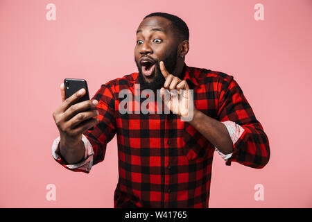 Portrait Of Happy afrikanischen Mann Shirt stehen über rosa Hintergrund isoliert, wobei selfie Stockfoto