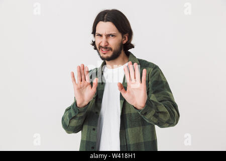 Porträt von einem erschrockenen jungen bärtigen Mann legere Kleidung stehen über Hintergrund, zeigt stop Geste Stockfoto