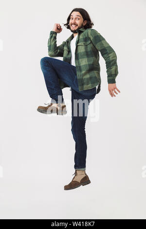 In voller Länge Porträt einer jungen bärtigen Mann legere Kleidung springen über Hintergrund, Erfolg feiern. Stockfoto