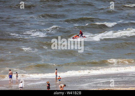 Egmond aan Zee, Niederlande - 18 Juli 2019: Mitglied der niederländischen Küstenwache" Reddingsbrigade' auf einem Jet-ski in der Nordsee, in der Nähe vom Strand mit Stockfoto