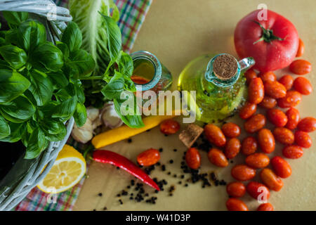 Basilikum, Pfeffer und Knoblauch. Vorbereitung einen Salat.. Tomaten und Aromen der Pizza. Flaschen mit gewürzten Öl. Geschmack von Italien Stockfoto