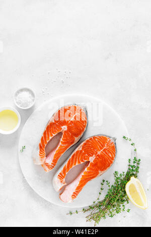 Frischer Lachs Steaks mit Zutaten zum Kochen auf dem Whiteboard, Ansicht von oben Stockfoto