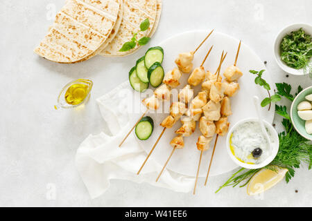 Gegrilltes Hühnchen Kebab am Spieß und traditionellen griechischen Tzatziki Joghurt Sauce, tview von oben Stockfoto