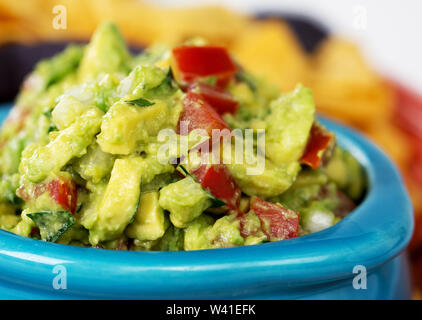 Nahaufnahme von einer Schale frische Guacamole mit Mais Tortilla Chips. Vorsätzliche flache Tiefenschärfe. Stockfoto