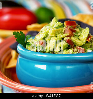 Eine Schale mit frischem Guacamole mit Mais Tortilla Chips. Vorsätzliche flache Tiefenschärfe. Stockfoto