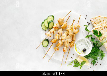Gegrilltes Hühnchen Kebab am Spieß und traditionellen griechischen Tzatziki Joghurt Sauce, tview von oben Stockfoto