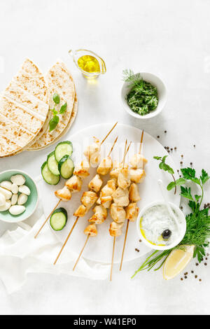 Gegrilltes Hühnchen Kebab am Spieß und traditionellen griechischen Tzatziki Joghurt Sauce, tview von oben Stockfoto