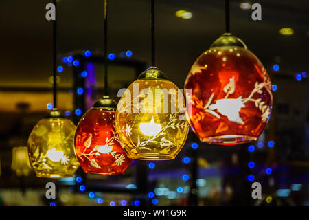 Eine Reihe von farbenfrohen roten und gelben Beleuchtungen gegen einen schönen blauen Lichtern bokeh Hintergrund. Stockfoto