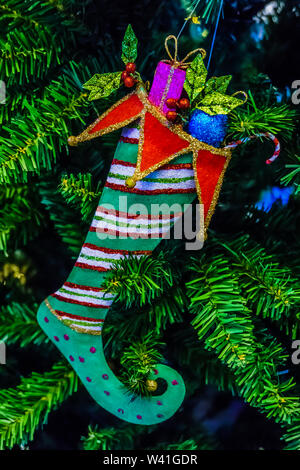 Fancy Weihnachtsstrumpf voller Geschenke am Weihnachtsbaum. Stockfoto