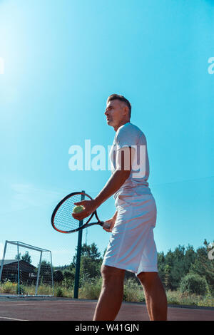 Schöner Mann tragen weiße Shorts holding Tennisschläger Stockfoto