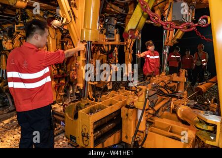 (190719) - NANCHANG, Juli 19, 2019 (Xinhua) - Konstruktoren verwenden, um eine große Stopfmaschine der neu festgelegten Titel in Nanchang City, East China's Jiangxi Province, 19. Juli 2019 beizubehalten. Mit kontinuierlichen über 1.000 Konstrukteurswertung acht Stunden streben, die Nanchang-Ganzhou high-speed Railway erfolgreich am Freitag zu Nanchang Transport Hub angeschlossen hat, was bedeutet, dass es formal hat China's High-speed rail Netzwerk angeschlossen. Die 415.734 Kilometer langen Nanchang-Ganzhou high-speed Railway mit einer Geschwindigkeit von 350 km pro Stunde links Nanchang City und Ganzhou in der Provinz Jiangxi. (Xinhu Stockfoto